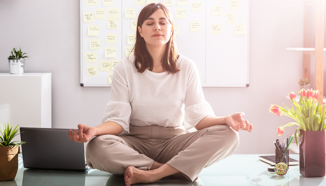 woman meditating sitting over a desk